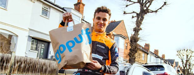 McLaren driver Lando Norris poses with a Gopuff delivery bag. (Photo by McLaren Racing and Gopuff)