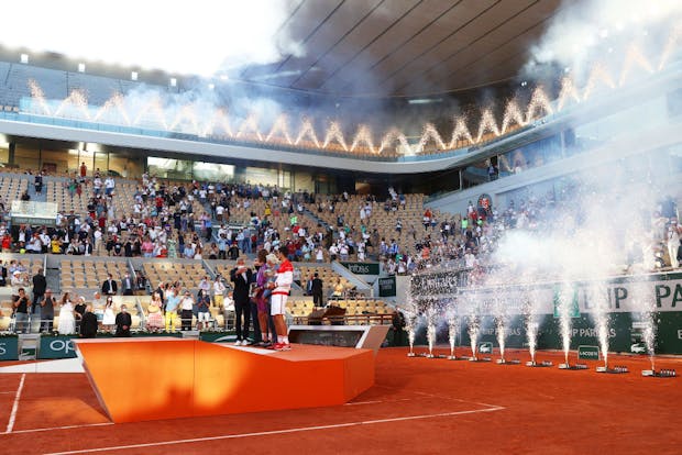 Court Philippe-Chatrier sees runner-up Stefanos Tsitsipas and winner Novak Djokovic stand with their respective trophies following the men's singles final at the 2021 French Open (by Julian Finney/Getty Images)