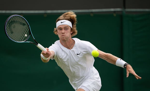 Andrey Rublev of Russia plays against Marton Fucsovics at the 2021 Wimbledon Championships (by AELTC/Jed Leicester - Pool/Getty Images).