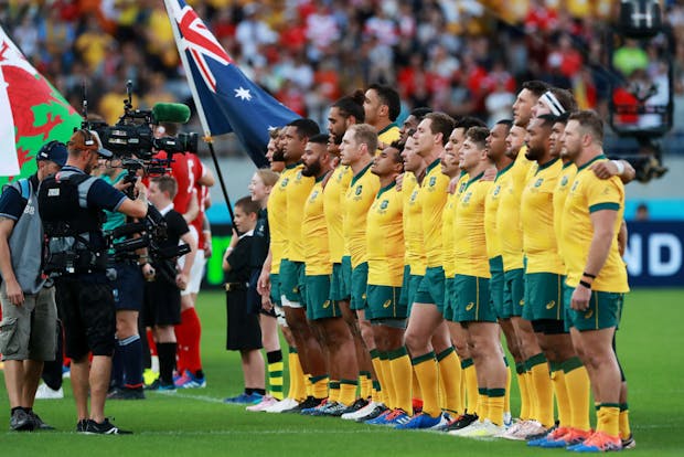 Australia players line up during national anthems prior to 2019 Rugby World Cup match versus Wales (Photo by David Rogers/Getty Images)