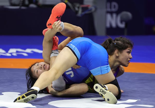 Sakura Motoki (blue) of Japan in action against Anastasia Nichita (red) of Moldova during the 2022 World Wrestling Championships (by Srdjan Stevanovic/Getty Images)