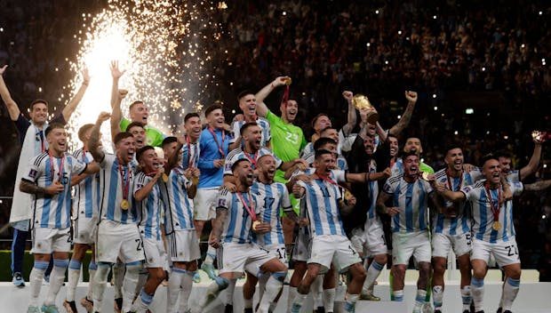 Lionel Messi lifts the trophy after winning the FIFA World Cup (Photo by