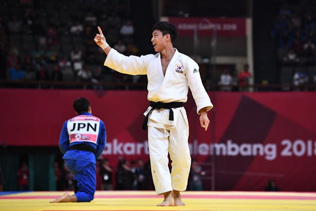 Baul An of Korea (white) celebrates victory in the Men's Judo 66kg Final at the 2018 Asian Games (by Robertus Pudyanto/Getty Images)