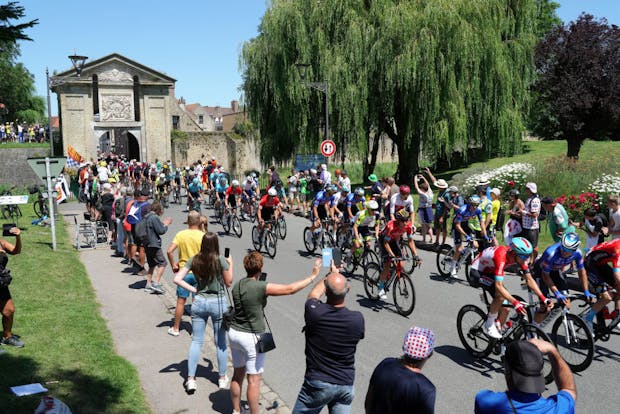 The peloton passes through Cassel's Door, main entrance of Bergues Village, during the fourth stage of the 2022 Tour de France (by Sylvain Lefevre/Getty Images)