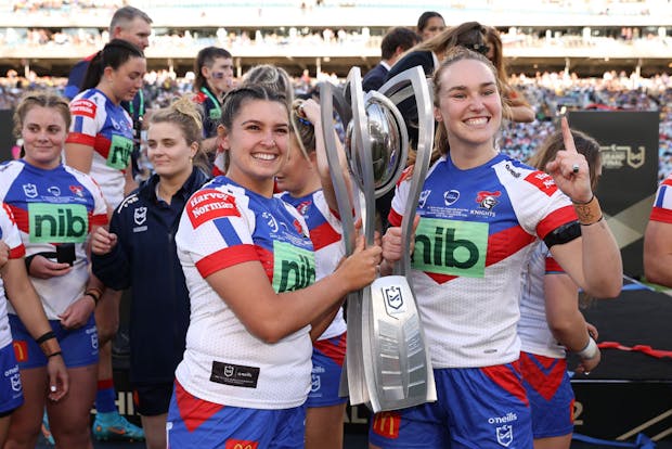 Bobbi Law and Kirra Dibb of the Knights celebrate with the NRLW Premiership trophy after victory in the 2022 Grand Final (by Cameron Spencer/Getty Images)