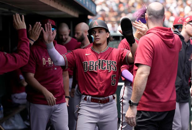 Alek Thomas of the Arizona Diamondbacks is congratulated by teammates after scoring against the San Francisco Giants. (Thearon W. Henderson/Getty Images)