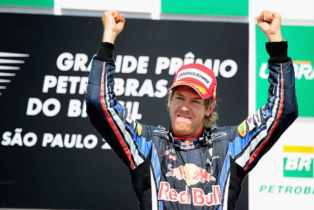Sebastian Vettel celebrates on the podium after winning the Brazilian Grand Prix on his way to securing the 2010 Formula 1 drivers' championship title (by Clive Mason/Getty Images)