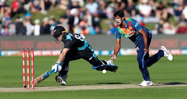 Sri Lanka player Nuwanidu Fernando unsuccessfully attempts to run out New Zealand's Tom Latham (Photo by James Allan/Getty Images)