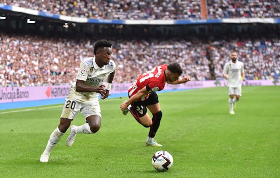 Vinicius Junior of Real Madrid dribbles the ball past Aitor Paredes of Athletic Club during the LaLiga match on June 4, 2023