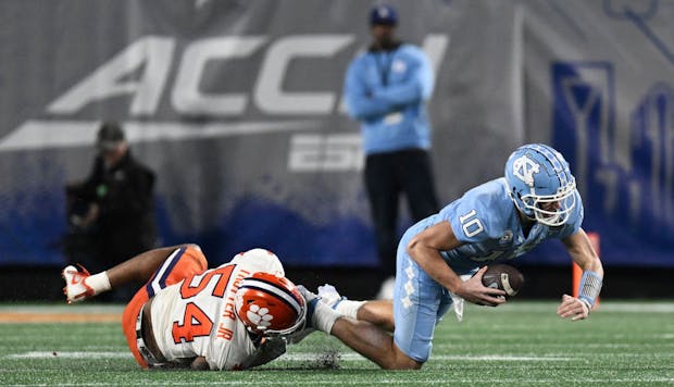 Jeremiah Trotter Jr. of the Clemson Tigers trips up Drake Maye of the North Carolina Tar Heels (Photo by Eakin Howard/Getty Images)