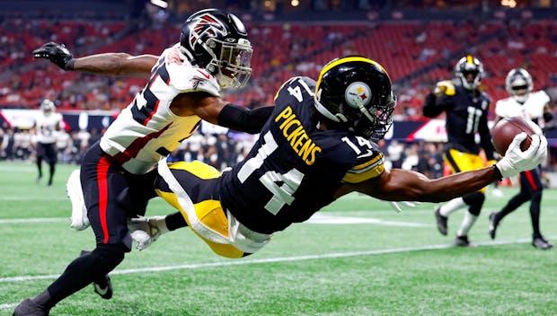 ATLANTA, GEORGIA - AUGUST 24: George Pickens #14 of the Pittsburgh Steelers leaps for a reception over Natrone Brooks #35 of the Atlanta Falcons during the first quarter of a preseason game at Mercedes-Benz Stadium on August 24, 2023 in Atlanta, Georgia. (Photo by