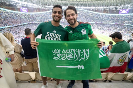 LUSAIL, QATAR - NOVEMBER 26: A Saudi Arabia and Mexico fan pose for a photograph with a Saudi Arabia flag after a FIFA World Cup Qatar 2022 Group C match between Mexico and Argentina at Lusail Stadium on November 26, 2022 in Lusail, Qatar. (Photo by