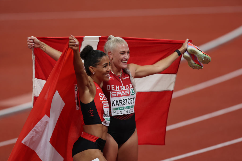 Bronze medalist Ida Karstoft of Denmark (R) and gold medalist Mujinga Kambundji of Switzerland (L) celebrate after athletics' women's 200m final at the 2022 European Championships