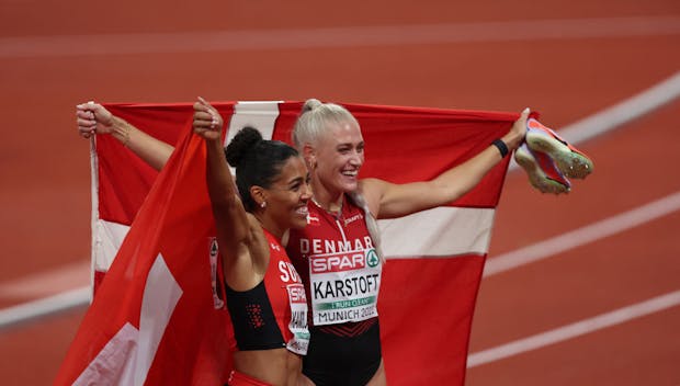 Bronze medalist Ida Karstoft of Denmark (R) and gold medalist Mujinga Kambundji of Switzerland (L) celebrate after athletics' women's 200m final at the 2022 European Championships