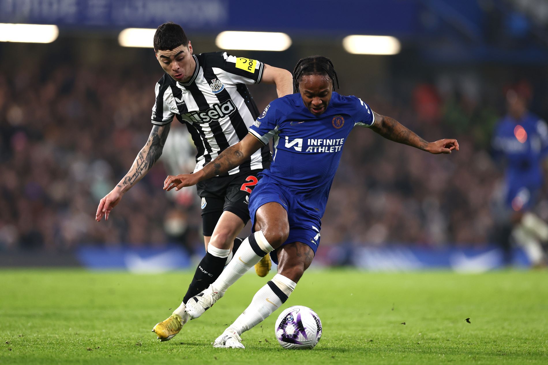 LONDON, ENGLAND - MARCH 11: Raheem Sterling of Chelsea is tackled by Miguel Almiron of Newcastle United during the Premier League match between Chelsea FC and Newcastle United at Stamford Bridge on March 11, 2024 in London, England. (Photo by Alex Pantling/Getty Images)