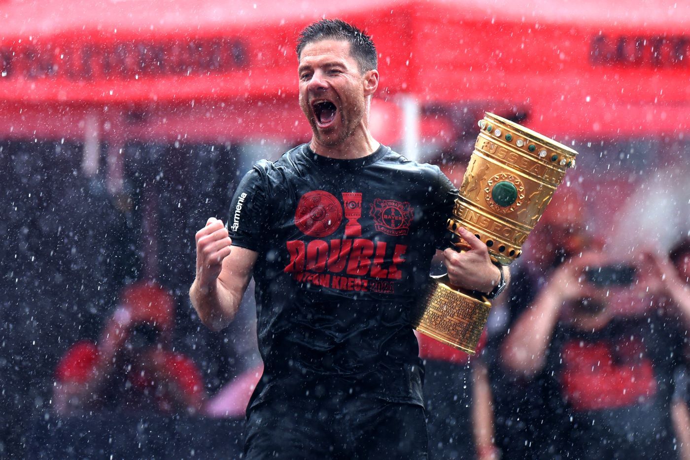 LEVERKUSEN, GERMANY - MAY 26: Xabi Alonso, Head Coach of Bayer 04 Leverkusen, celebrates with the DFB-Pokal trophy during the Bayer 04 Leverkusen champions party at BayArena on May 26, 2024 in Leverkusen, Germany. (Photo by Dean Mouhtaropoulos/Getty Images)