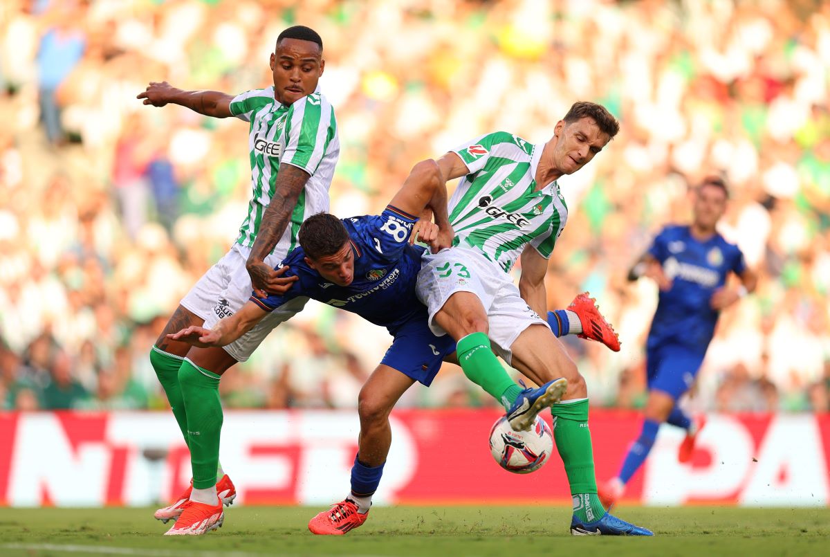 SEVILLE, SPAIN - SEPTEMBER 18: Bertug Yildirim of Getafe CF battles for possession with Natan and Diego Llorente of Real Betis during the LaLiga match between Real Betis Balompie and Getafe CF at Estadio Benito Villamarin on September 18, 2024 in Seville, Spain. (Photo by Fran Santiago/Getty Images)