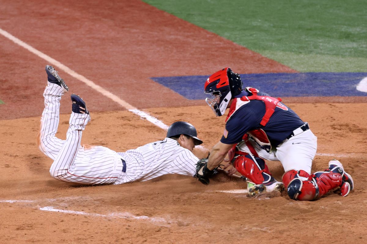 YOKOHAMA, JAPAN - AUGUST 07: Designated hitter Tetsuto Yamada #1 of Team Japan slides safely into the home plate to score a run by the throwing error of Outfielder Jack Lopez #7 of Team United States in the eighth inning during the gold medal game between Team United States and Team Japan on day fifteen of the Tokyo 2020 Olympic Games at Yokohama Baseball Stadium on August 07, 2021 in Yokohama, Kanagawa, Japan. (Photo by Koji Watanabe/Getty Images)