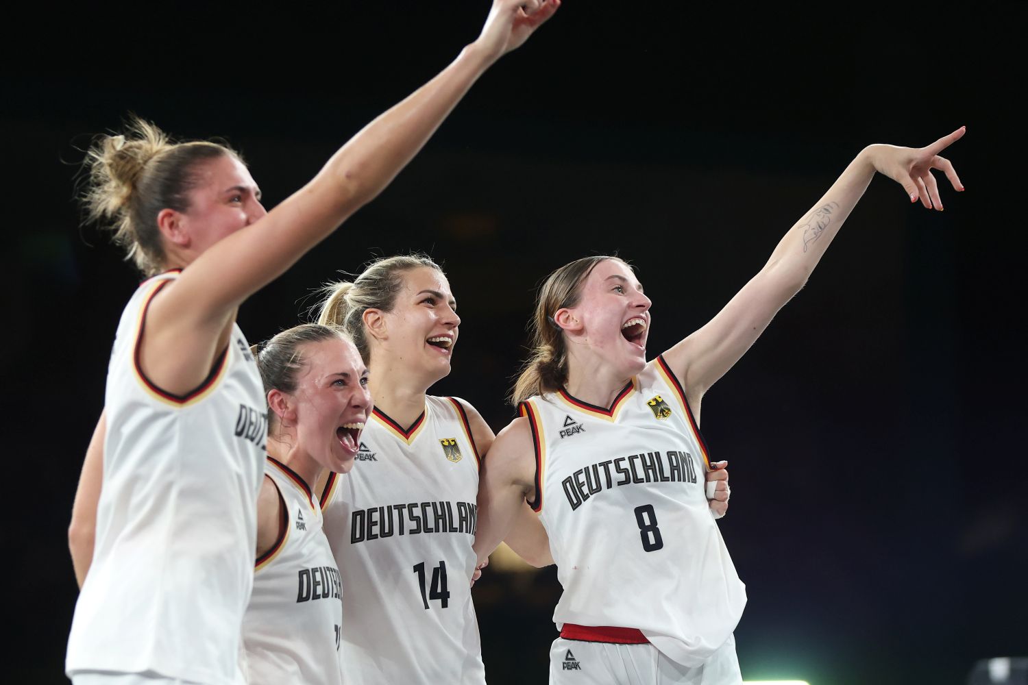 PARIS, FRANCE - AUGUST 05: Marie Reichert #6, Sonja Greinacher #14, Svenja Brunckhorst #21 and Elisa Mevius #8 of Team Germany celebrate after their victory against Spain during a Women's 3x3 basketball Gold medal game between Germany and Spain on day ten of the Olympic Games Paris 2024 at Esplanade Des Invalides on August 05, 2024 in Paris, France. (Photo by Matthew Stockman/Getty Images)