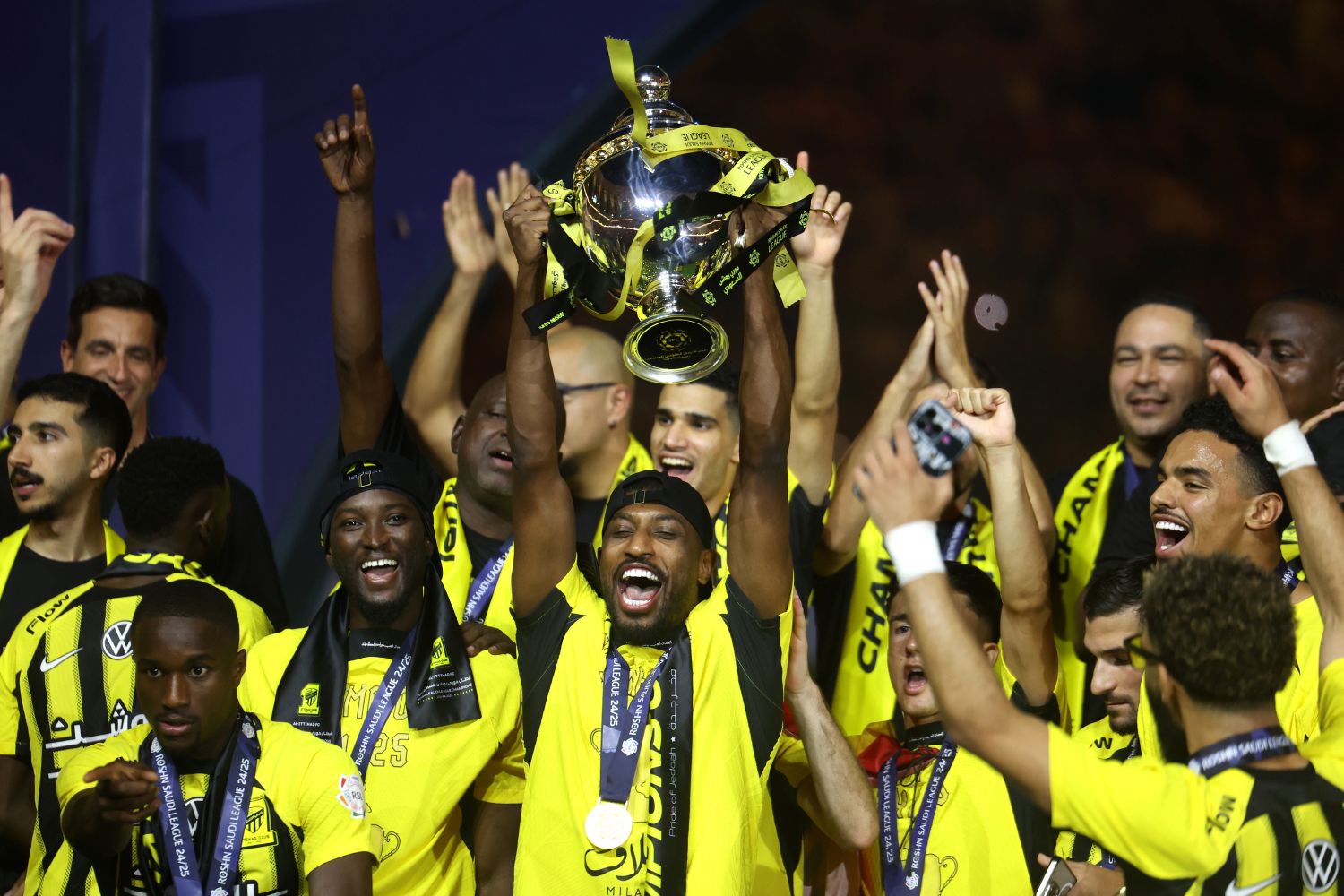 JEDDAH, SAUDI ARABIA - MAY 26: Ahmed Sharahili of Al-Ittihad lifts the Saudi Pro League trophy with teammates following the team's victory in the Saudi Pro League match between Al Ittihad and Damac FC at Alinma Stadium on May 26, 2025 in Jeddah, Saudi Arabia. (Photo by Yasser Bakhsh/Getty Images)