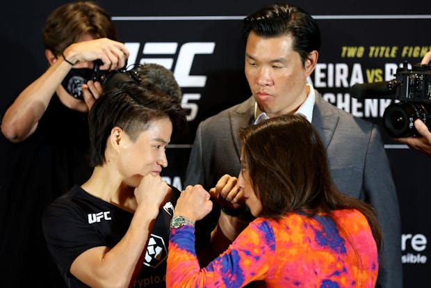 Zhang Weili (L) of China and Joanna Jedrzejczyk of Poland face off ahead of UFC 275 as UFC SVP Kevin Chang looks on, in Singapore, June 2022. (Photo by Yong Teck Lim/Getty Images)