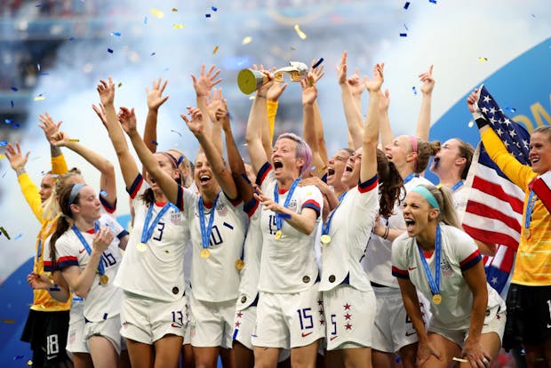 USA players celebrate with the trophy following the 2019 Fifa Women's World Cup final (by Marc Atkins/Getty Images)