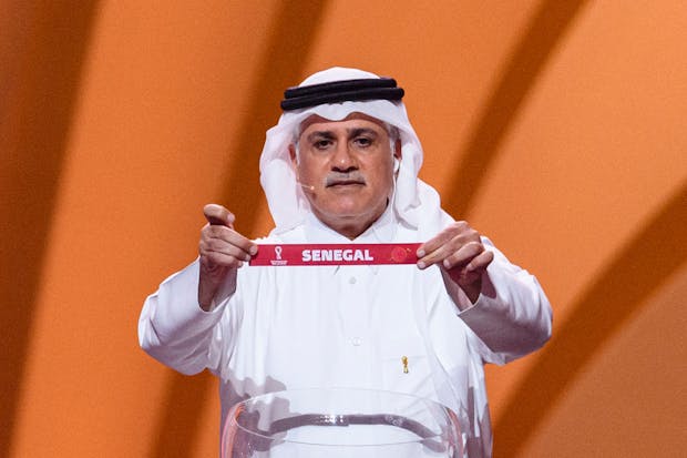 Ex-Qatar footballer  Adel Ahmed MalAllah shows Senegal name during 2022 Fifa World Cup draw in Doha (Photo by Marcio Machado/Eurasia Sport Images/Getty Images)