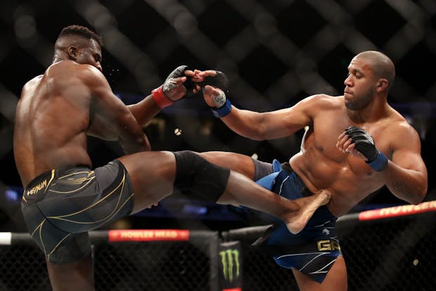 Francis Ngannou of Cameroon (left) exchanges kicks with Ciryl Gane of France during heavyweight title fight on January 22, 2022 (by Katelyn Mulcahy/Getty Images)