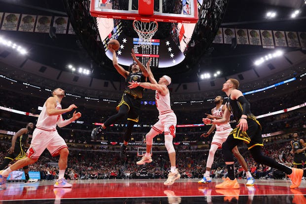 Anthony Lamb of the Golden State Warriors goes up for a layup against Alex Caruso of the Chicago Bulls (Photo by Michael Reaves/Getty Images)