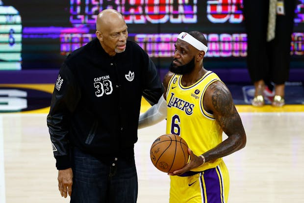 Kareem Abdul-Jabbar hands LeBron James the ball after James passed Abdul-Jabbar to become the NBA's all-time leading scorer (Getty Images)