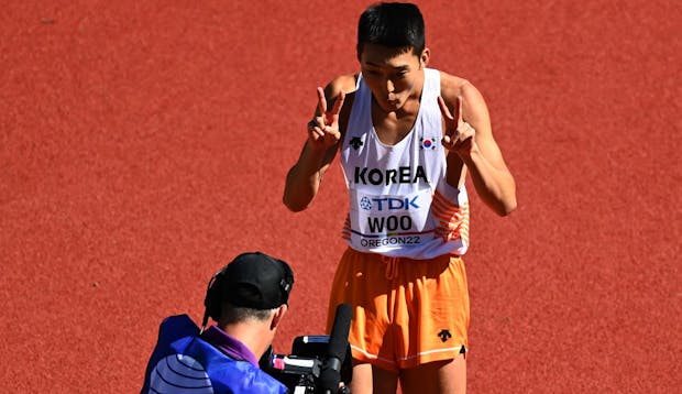 Korean high jumper Sanghyeok Woo reacts to a TV camera at 2022 World Athletics Championships in Oregon (Photo by Hannah Peters/Getty Images for World Athletics)