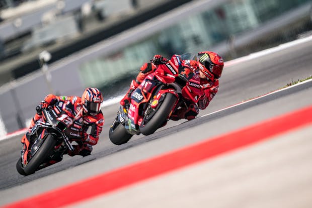 Francesco Bagnaia leads the race in front of Maverick Viñales during MotoGP's Grande Prémio de Portugal on March 26, 2023 (by Steve Wobser/Getty Images)