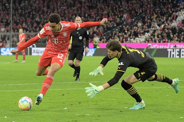 Jamal Musiala of FC Bayern München in action with Gregor Kobel of Borussia Dortmund during the Bundesliga match on April 1, 2023 (by Fantasista/Getty Images)