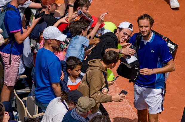 Daniil Medvedev takes selfies with fans during the 2022 French Open (by Andy Cheung/Getty Images)