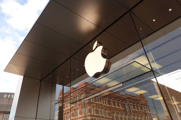 The Apple company logo hangs above an Apple retail store (Photo by Scott Olson/Getty Images)