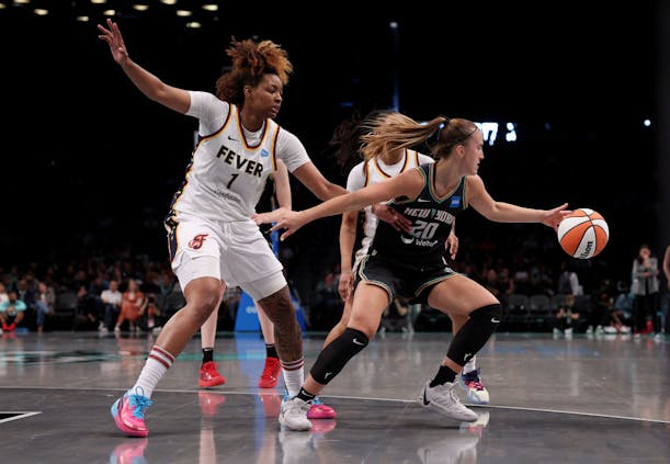 Sabrina Ionescu, #20 of the New York Liberty, grabs the ball as NaLyssa Smith, #1 of the Indiana Fever, defends during a WNBA game on May 21, 2023 (by Elsa/Getty Images)
