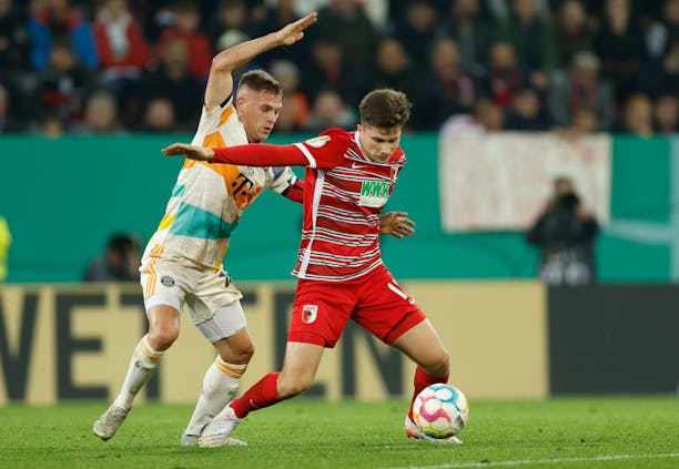 Joshua Kimmich of FC Bayern Munich and Elvis Rexhbecaj of FC Augsburg during the DFB-Pokal second round match (by Boris Schumacher ATPImages/Getty Image)