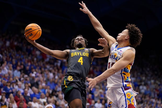 LJ Cryer, #4 of the Baylor Bears, lays the ball up against Jalen Wilson, #10 of the Kansas Jayhawks, during a game on February 18, 2023 (by Ed Zurga/Getty Images)