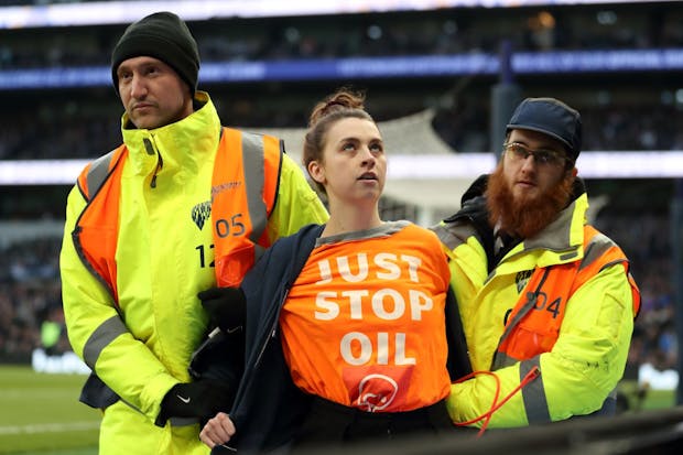 A just stop oil protestor removed by stewards during the Premier League match between Tottenham Hotspur and West Ham United at Tottenham Hotspur Stadium in March 2022. (Photo by James Williamson - AMA/Getty Images).