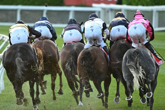 MELBOURNE, AUSTRALIA - DECEMBER 15: Horses and riders bunched up on the home turn in Race 4, the Ladbrokes 55 Second Challenge - Heat 9 during Melbourne Racing at Moonee Valley Racecourse on December 15, 2023 in Melbourne, Australia. (Photo by